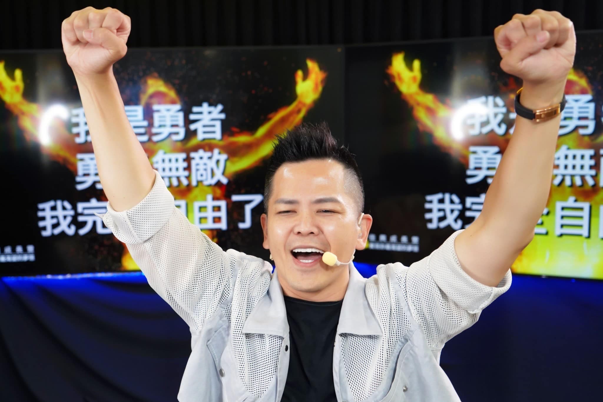 黃佳興在講台上以手勢與表情說明溝通內容